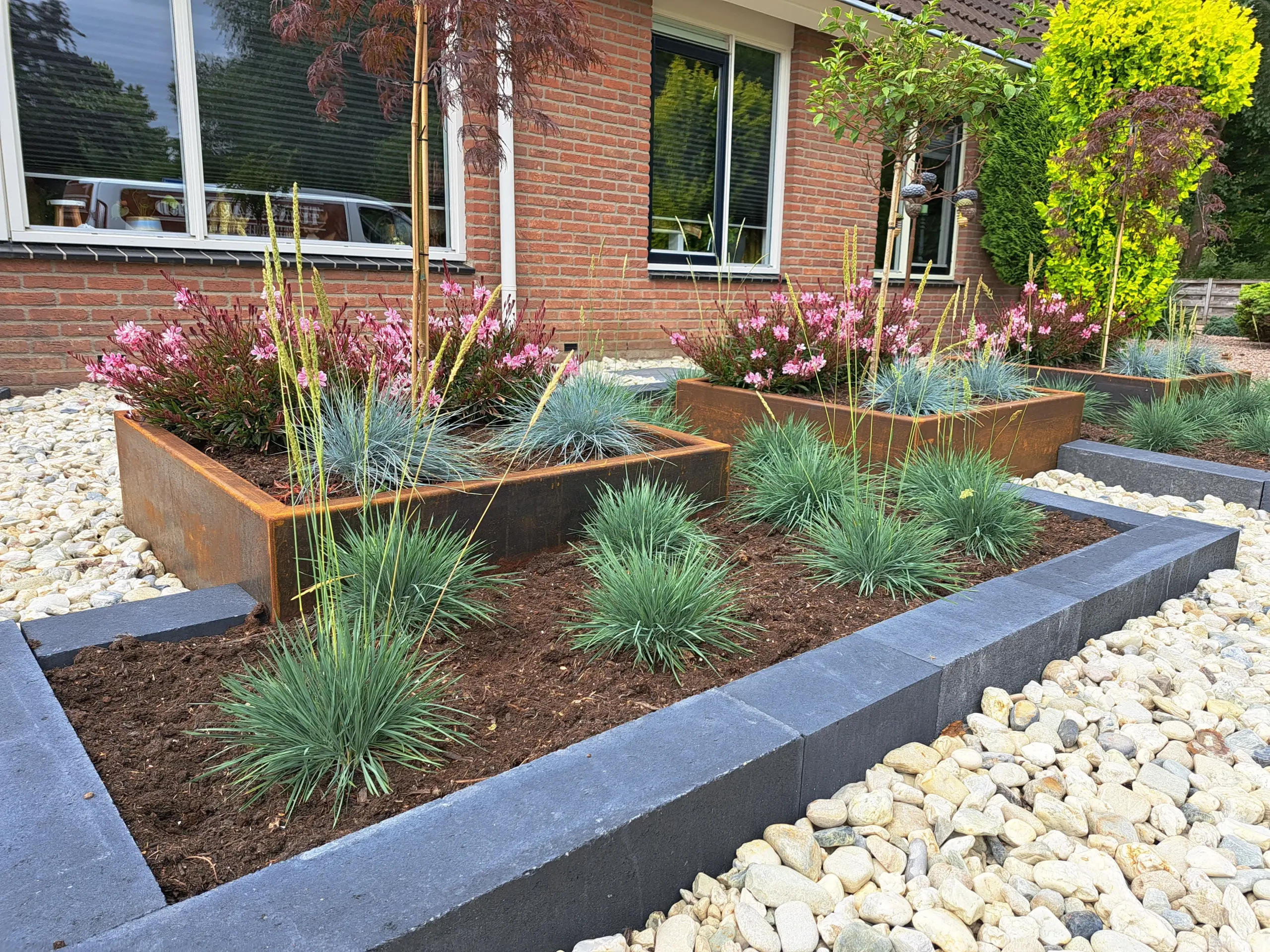 Cortenstalen tuininrichting met verhoogde bloembakken en beplanting